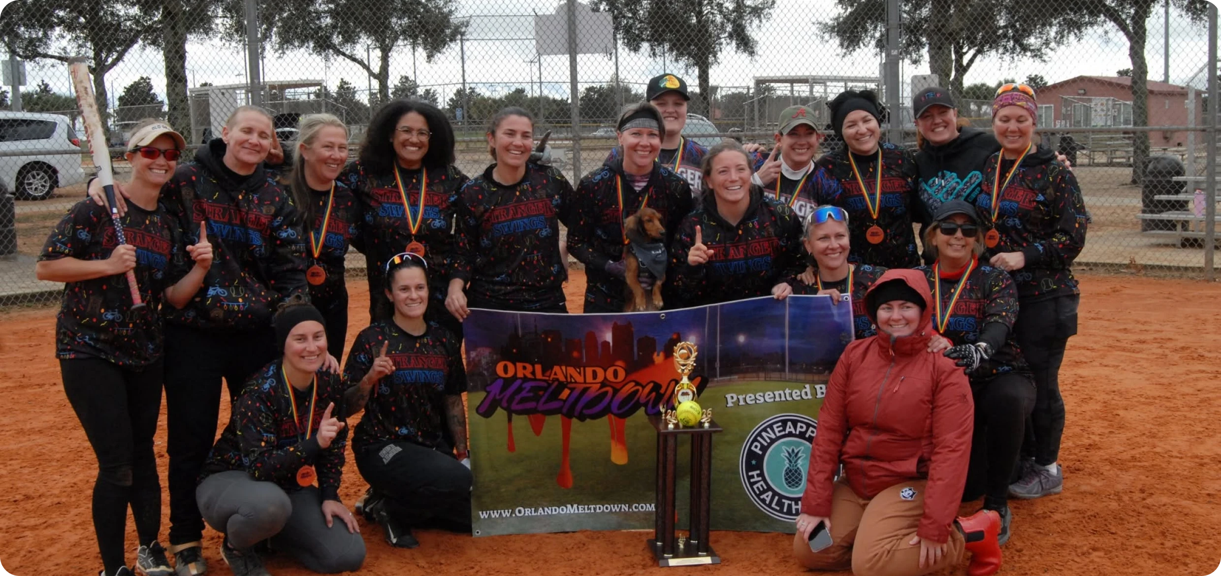 Softball team celebrating with trophy